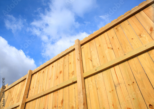 Photographie Wooden fence against a cloudy sky