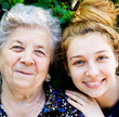 Old happy woman and young caring daughter outdoors