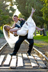 A young groom carrying his bride