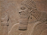 Fototapeta Londyn - Ancient Assyrian wall carving of a man showing his head and hand
