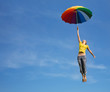 canvas print picture - Flying girl with colorful umbrella in the blue blue sky
