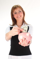 Woman putting money in a Piggy Bank