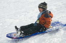 Boy Sledding In The Snow