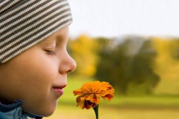 3 years old boy smelling flower