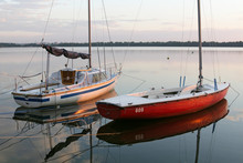 Sail Boat Anchored In Bay At Sunset