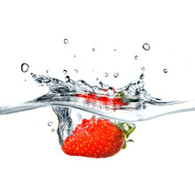 Strawberry Dropped Into Blue Water With Splash Isolated On White