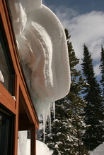 A Snow Cornice Hangs Off A Roof  In Colorado Ski Country.