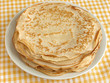 pancakes pile on yellow tablecloth