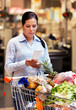 Frau kontrolliert Kassenzettel im Supermarkt