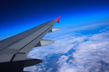 Aircraft wing flying high above the clouds