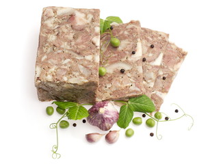 Pressed meat of the heads decorated with garlic and green pea