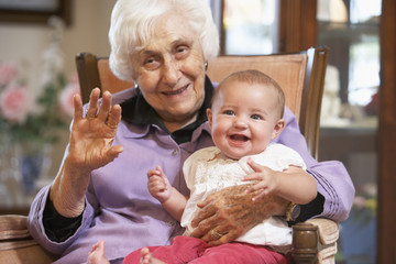 Wall Mural - Grandmother holding her granddaughter on lap