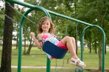 beautiful little girl playing with swing