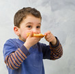 young boy eating pizza