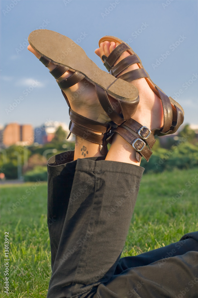Resting Young Woman Feet in Sunny Outdoor and Blue Sky