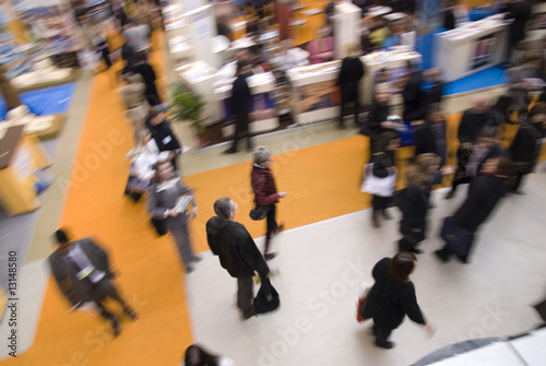 Visitors passing by stands at exhibition Wallpaper Mural