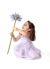 Little Girl Spinning A Large Stemmed Flower With Delight