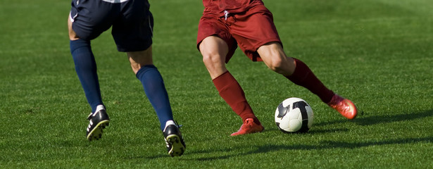 Soccer players running after the ball