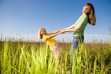 Wall Mural - Happy mother and daughter at field