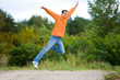 © Eduard Stelmakh - Happy Young Man - jumping in the sky against a green tree