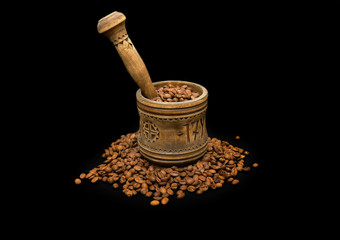 The old mortar , coffee beans on black background.