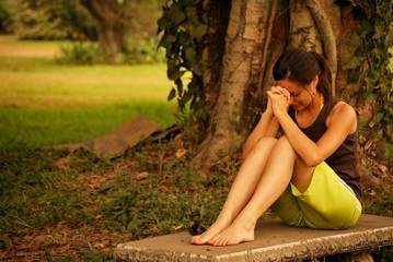 Hispanic woman praying outside