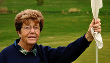 Portrait Of Senior Woman Golfer Holding A Flagstick