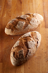 Two pieces ob bread loaf made of rye flour on wooden desk