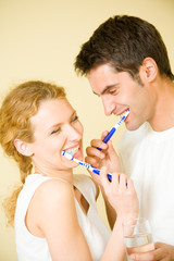 Canvas Print - Young couple cleaning teeth together at bathroom