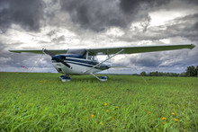 Aircraft On The Field Against Thunderstorm Clouds Background
