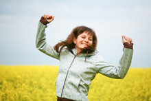 Happy Girl With Fluttering Hair In Flower Field