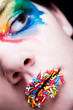 Colorful make-up with candy on her lips