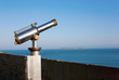 Coin operated viewfinder telescope overlooking sea shore