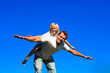 © WavebreakMediaMicro - Young boy on father's back playing airplane