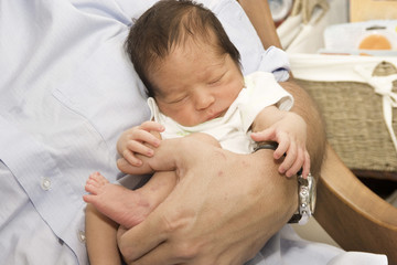 newborn baby sleeping on dad