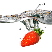 Strawberry Dropped Into Water With Splash Isolated On White
