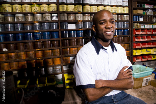 Fotomural Man sitting in front of colored inks in print shop