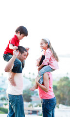 Wall Mural - Parents giving their children piggyback rides