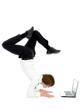 © pikselstock - Businessman doing handstand and using laptop