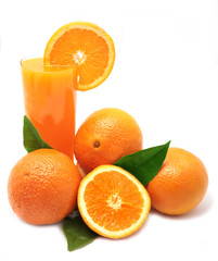 Oranges with green leaves and glass of juice on a white backgrou