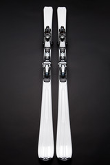 white skis on black skiing towards camera