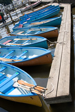 Blue Rowing Boats In Line By A Jetty