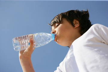  Portrait d'un garçon buvant de l'eau à la bouteille