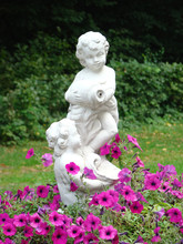 Sculpture Of Children In A Flowerbed From Pink Petunias