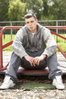 © Monkey Business - Young Man Sitting In Playground