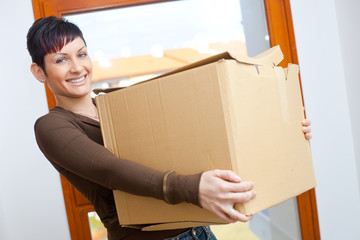 Canvas Print - Young woman lifting cardboard box