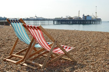 deckchairs on brighton beach and pier, england