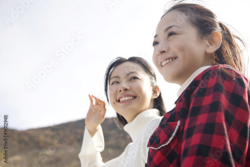 遠くの景色を眺めている笑顔の女性2人 Stock Photo Adobe Stock