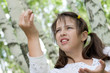Cute brunette girl standing outdoor holds found larva