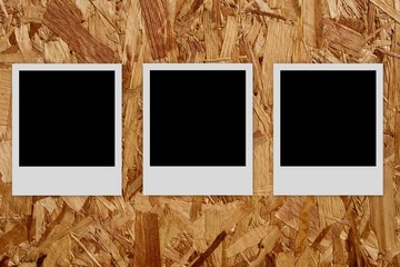 Three empty photo frames  on wood background